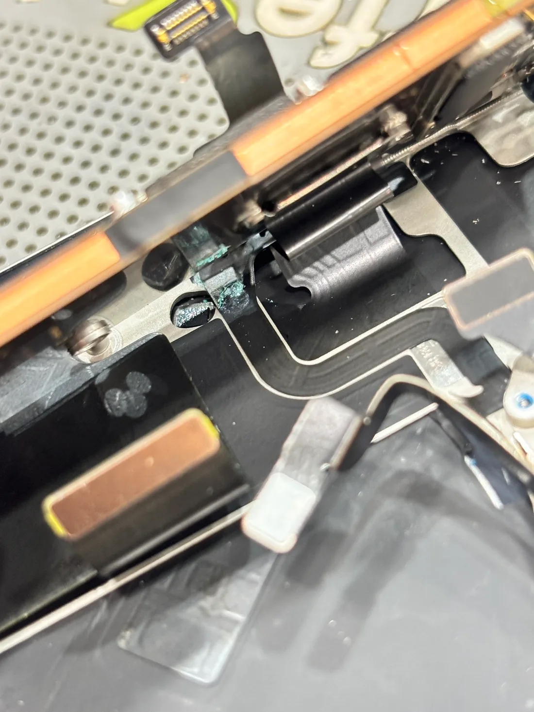 iPhone 15 Pro 拆機微距,開機音量排線接點出現藍綠色腐蝕結晶
