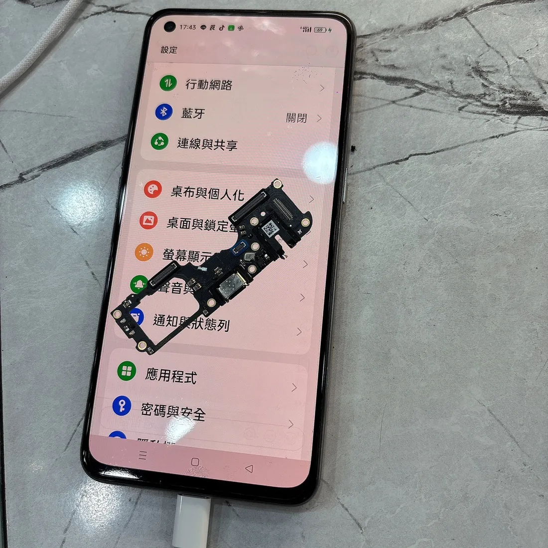 realme GT 大師版換尾插後正常充電,螢幕上是拆下來的舊尾插小板