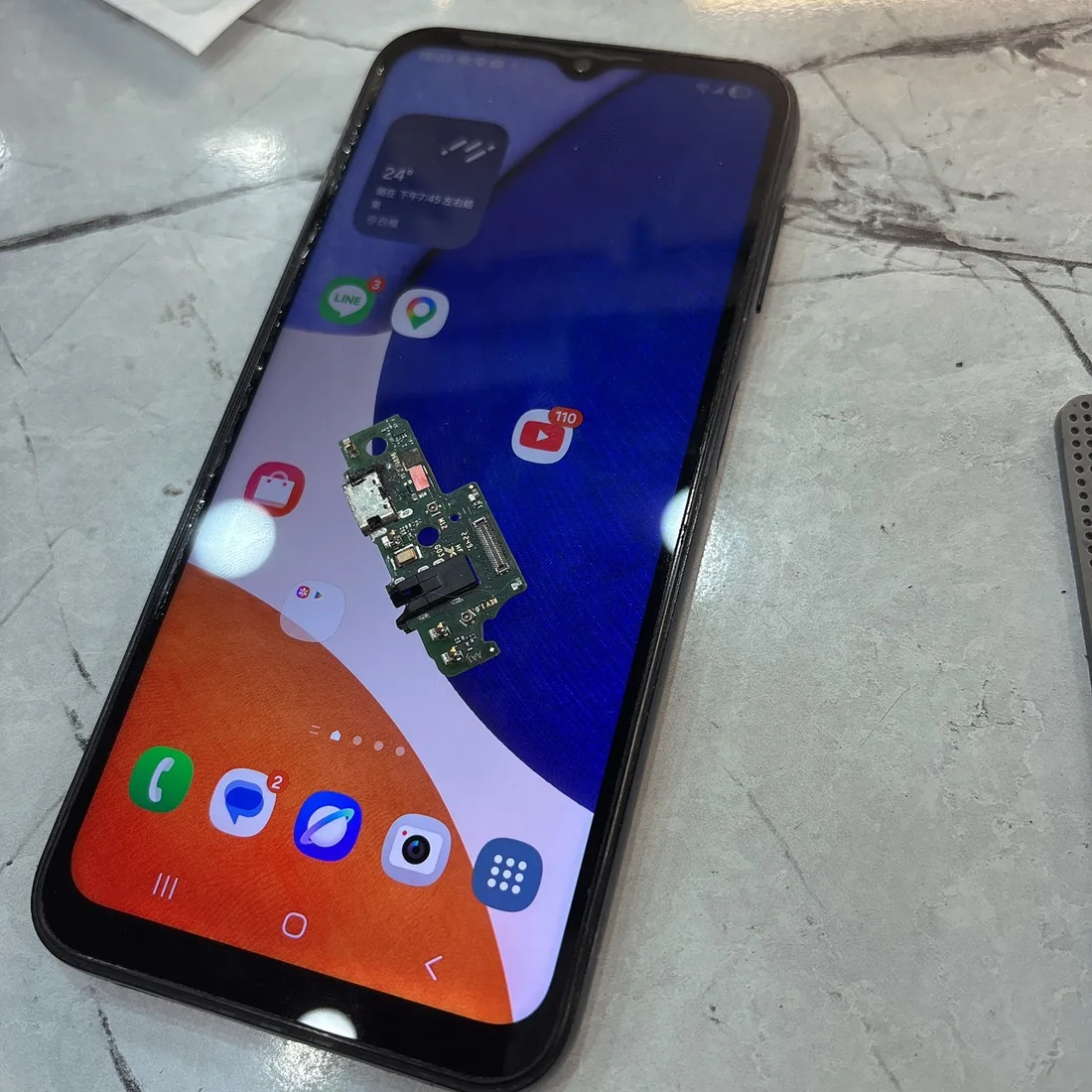 三星 Galaxy A14 修復後正常開機,機身上是換下來的尾插小板