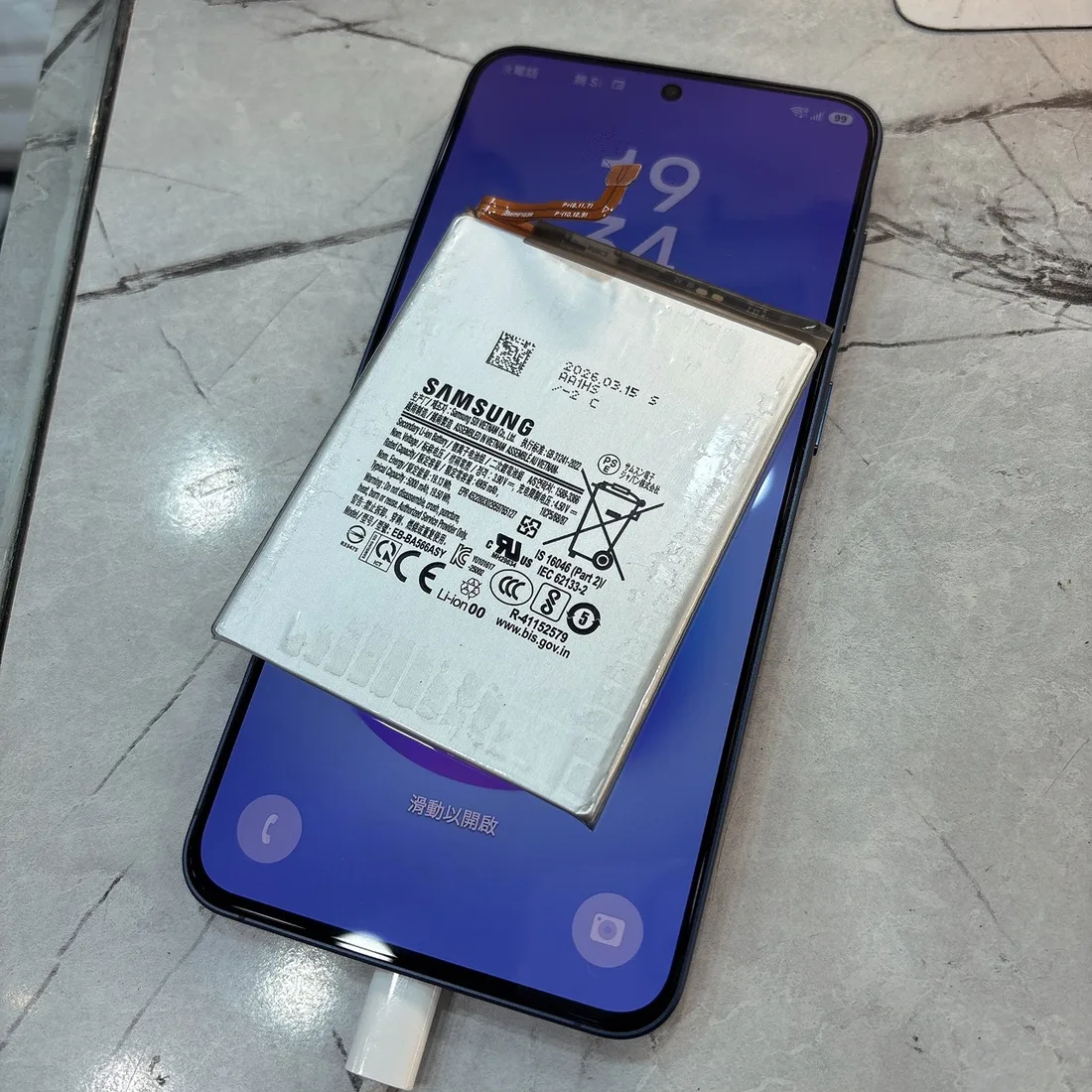 三星 Galaxy A57 換電池後正常充電,上方是換下的舊電池