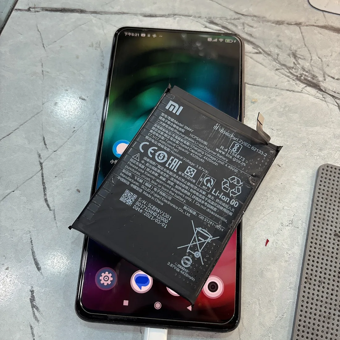 小米 9T Pro 換電池後正常充電,上方是換下的舊電池 BM4Y