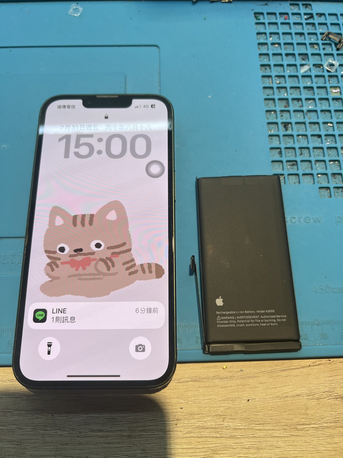 頭份 Fix Star 完成 iPhone 13 換電池,手機正常開機,右側是拆下的舊電池 A2655