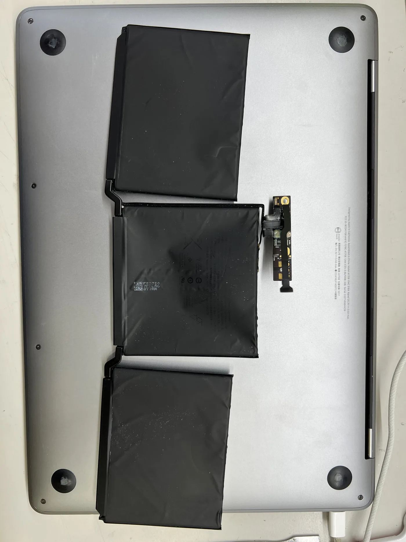 MacBook Pro A1708 拆下的舊電池,三組電芯與右側的電池控制小板