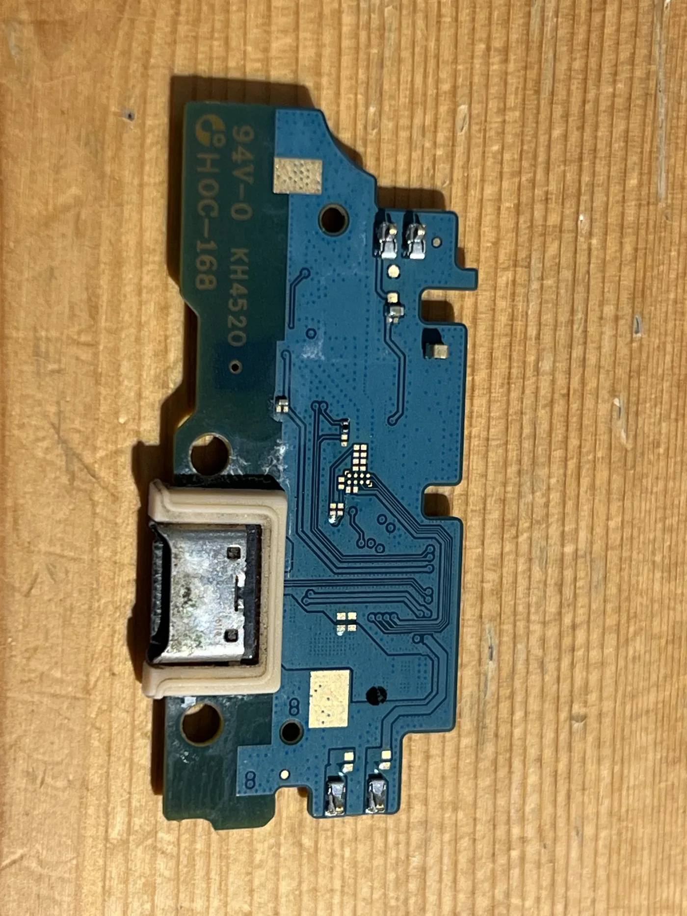 三星 Galaxy A16 拆下的充電尾插小板,USB-C 孔內有白色腐蝕物