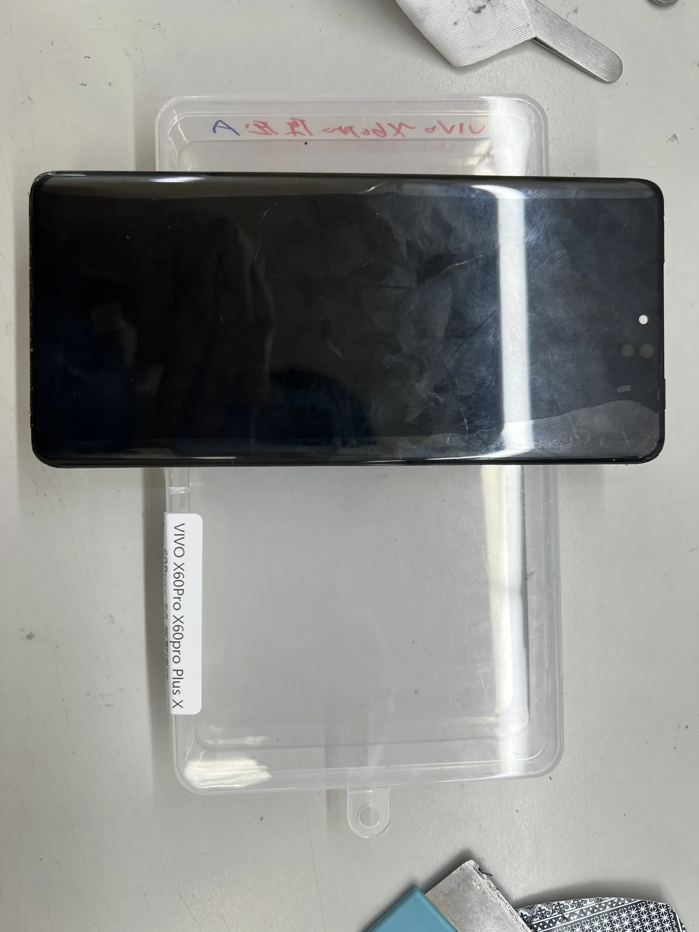 vivo X60 Pro 更換用的曲面螢幕總成,放在標示適用機型的零件包裝盒上